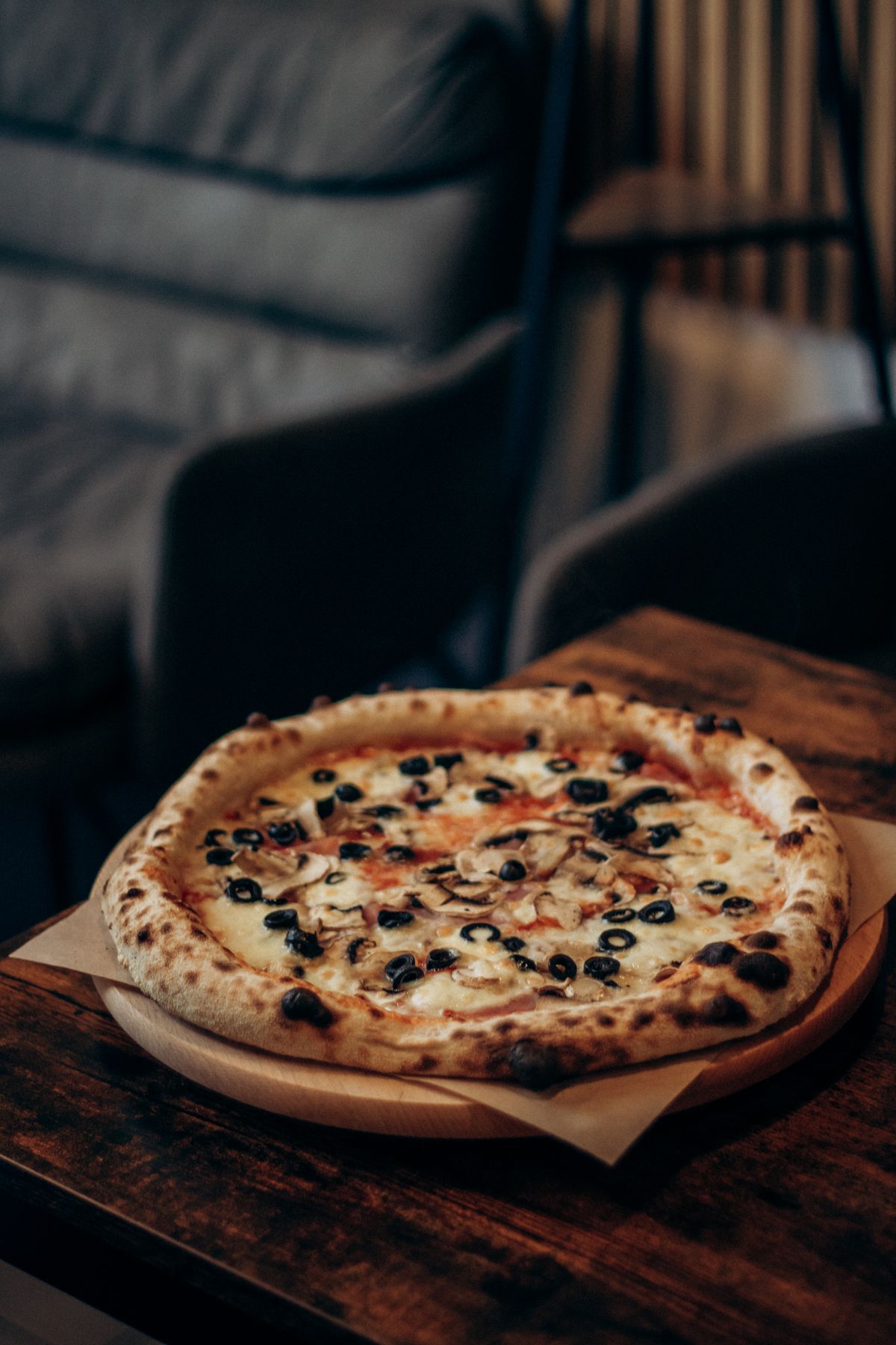 Pizza artisanale sortant du four, ambiance chaleureuse de pizzeria